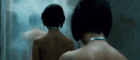 a woman with a choker around her neck stands in a shower