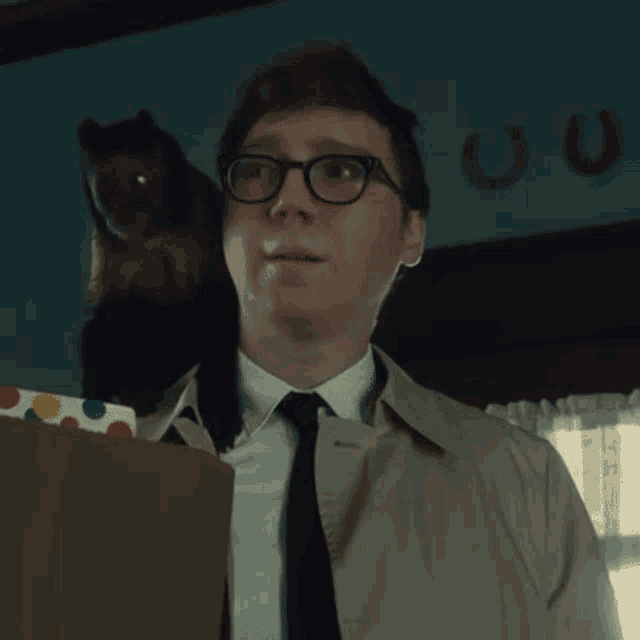 a man in a suit and tie with a cat on his back