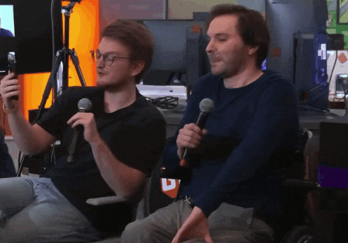 a man holding a microphone next to another man
