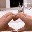 a person is making a heart shape with their hands in front of a computer .