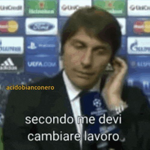 a man in a suit and tie talking on a cell phone with the words secondo me devi cambiare lavoro written below him