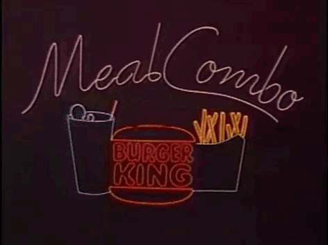a person is holding a hamburger with tomatoes lettuce and pickles