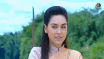 a woman in a white shirt is holding a sword in her hand .