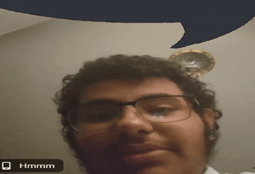 a man wearing glasses has a speech bubble above his head that reads hmm