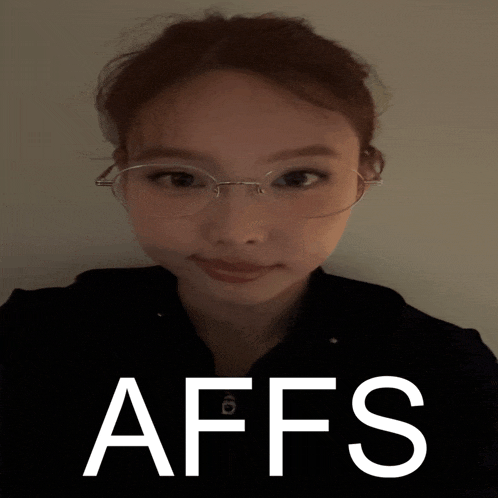a woman wearing glasses is standing in front of a poster that says affs