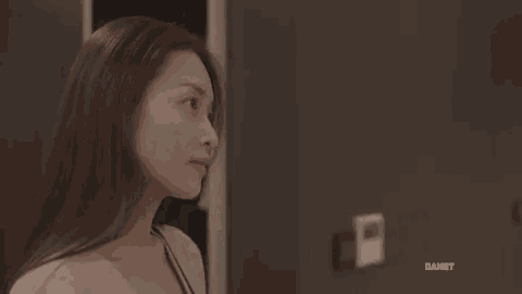 a woman is standing in front of a door looking at the camera .