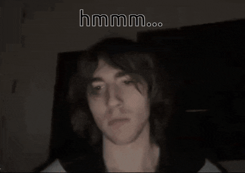 a man with braces on his teeth is smiling in the dark with a caption that says hmmm