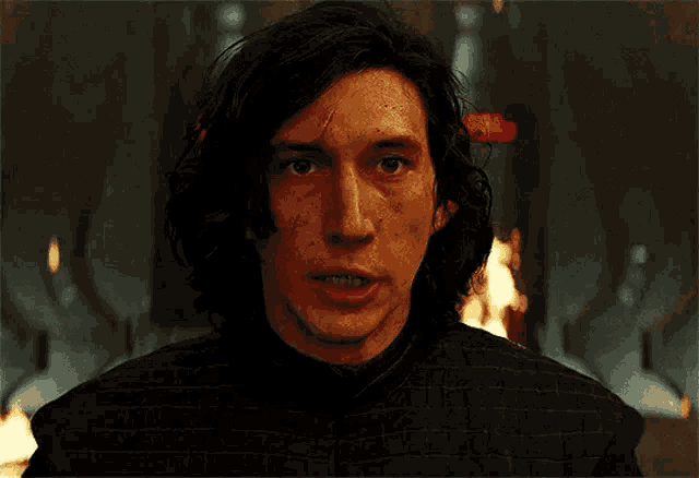 a close up of a man 's face with fire in the background .