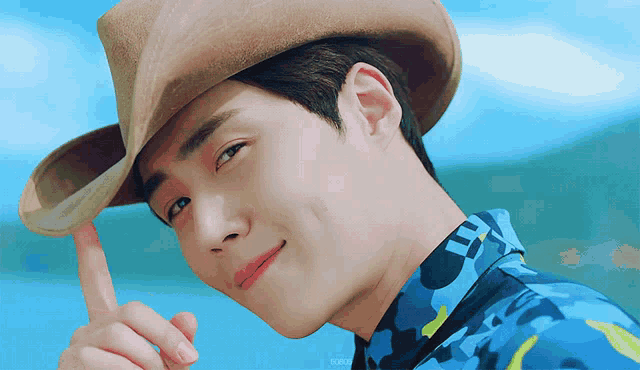 a close up of a man wearing a cowboy hat and a camouflage shirt