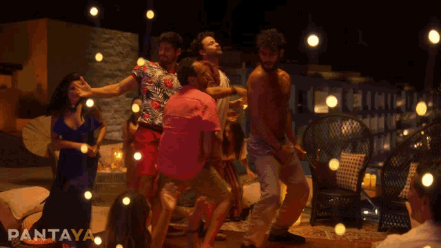 a group of people are dancing in front of a sign that says pantaya on it