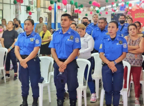 a group of police officers stand in front of a crowd of people