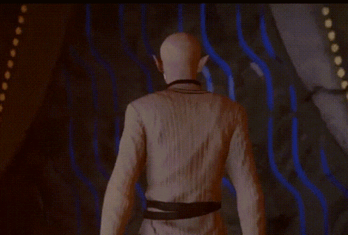 a man with a mask on his head is standing in front of a wall