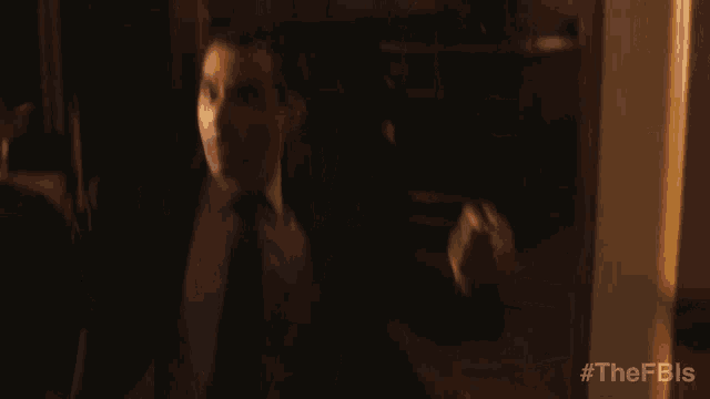 a blurred image of a man in a suit and tie with the hashtag #thefbis on the bottom