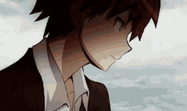 a close up of a man in a suit and tie looking down at something .