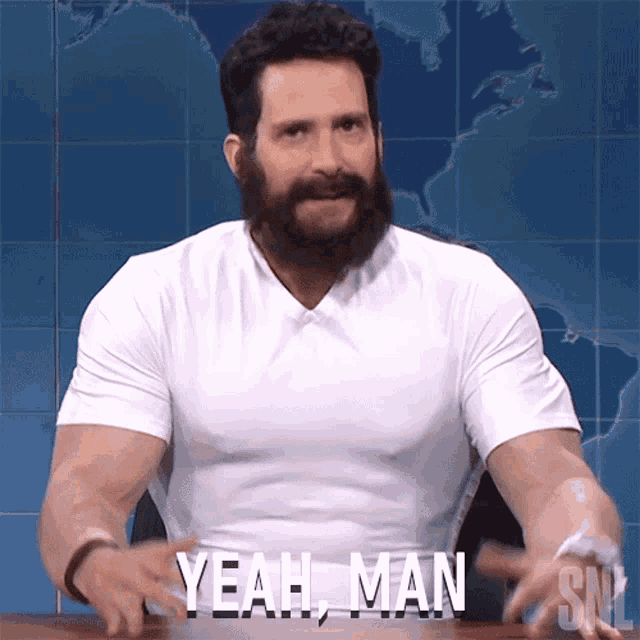 a man with a beard wearing a white shirt that says yeah man
