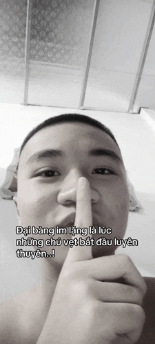 a man holds his finger to his mouth and says " dai bang im lang la luc nhung chu vet bat dau lyen thuyen "