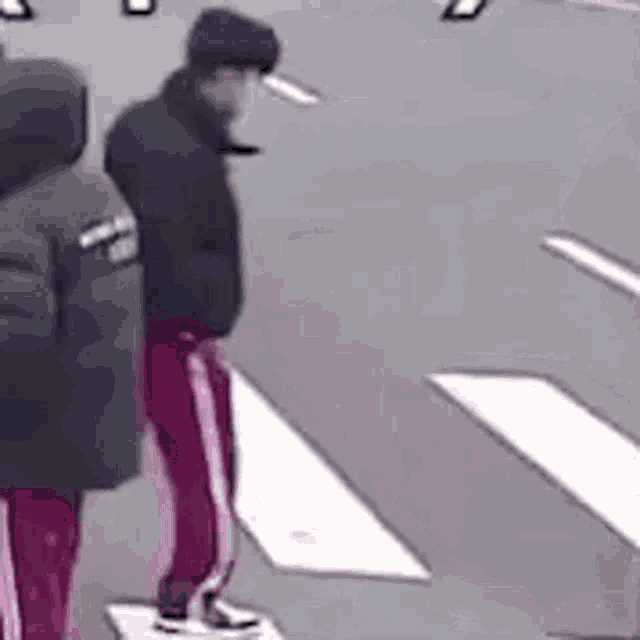 a group of people are standing on a sidewalk .
