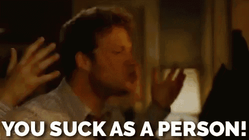 a man is yelling at another man with the words `` you suck as a person '' written above him .