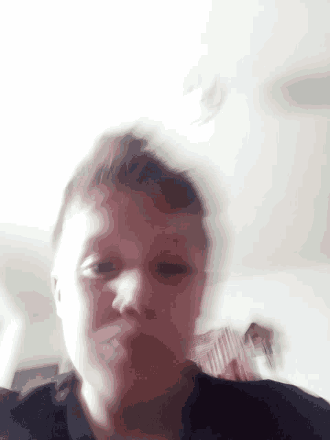 a blurry picture of a young boy 's face with a chair in the background