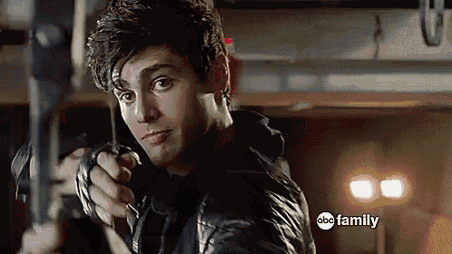 a man in a black leather jacket is holding a knife in front of an abc family sign