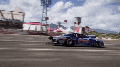 a blue summit race car is driving down a track