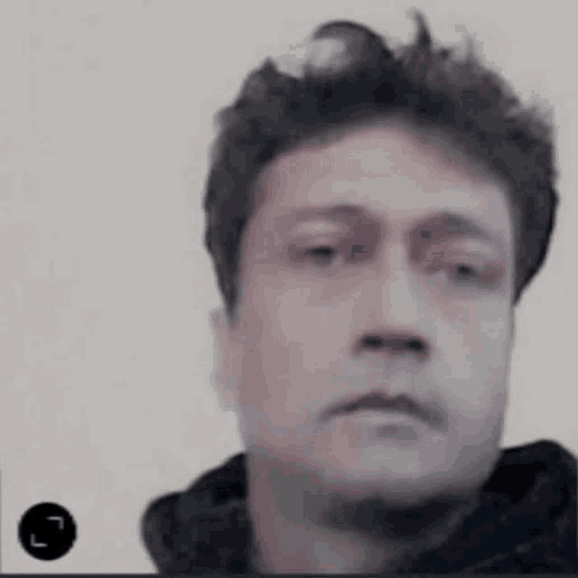 a close up of a man 's face with a hoodie on .