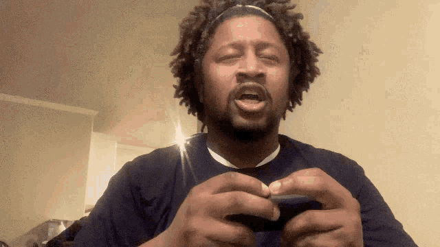 a man wearing a headband is holding a cell phone