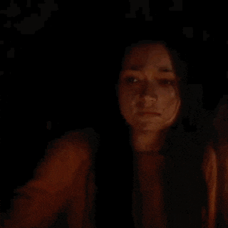 a woman is taking a selfie in the dark with her face covered in blood .