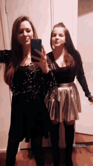 two women are taking a selfie in front of a mirror with their phones