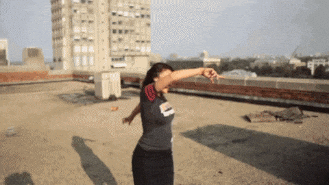 a woman dancing on a rooftop wearing a shirt that says ' chicago ' on it