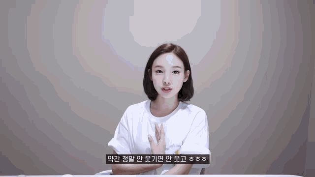 a woman in a white shirt is sitting at a table with a foreign language subtitle