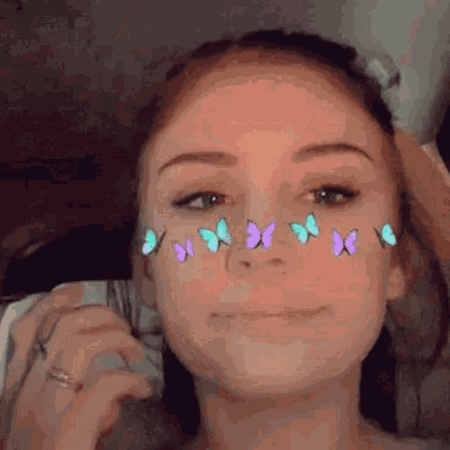 a close up of a woman 's face with butterflies on her face .