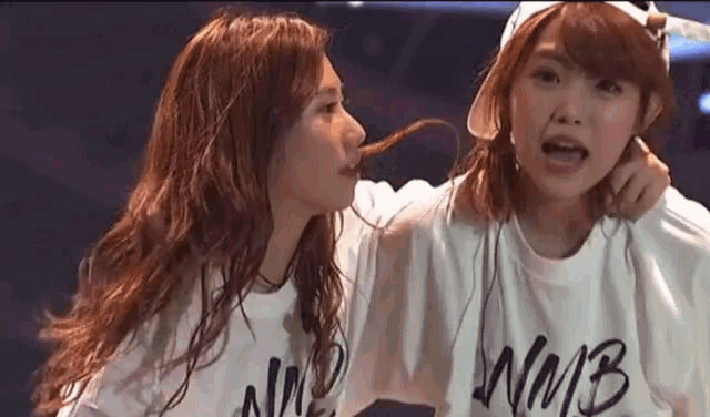 a couple of girls are standing next to each other .