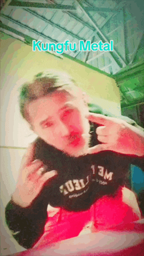 a man wearing a black shirt that says kungfu metal on it