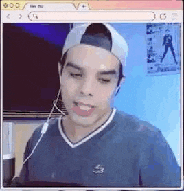 a man wearing a baseball cap and headphones is smiling while looking at a computer screen .