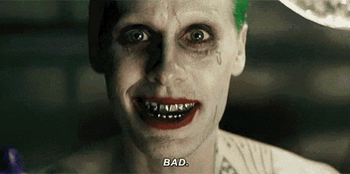 the joker from the movie suicide squad is smiling with braces on his teeth and red lipstick .