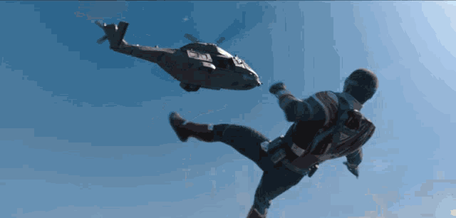 a man in a superhero costume is kicking a helicopter in the sky