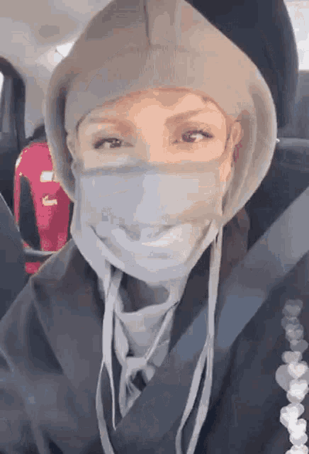 a woman wearing a face mask and a hooded jacket