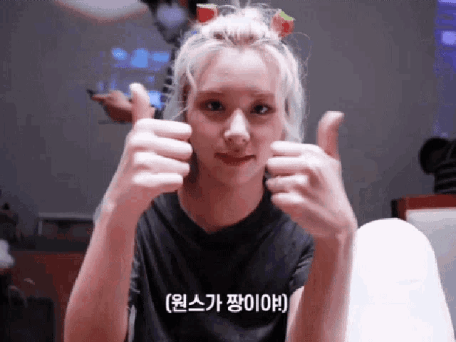 a woman with a watermelon in her hair is giving a thumbs up .