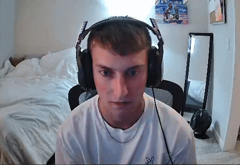 a young man wearing headphones is sitting in front of a bed