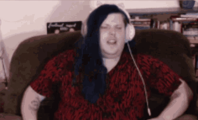 a woman wearing headphones is sitting in a chair and singing