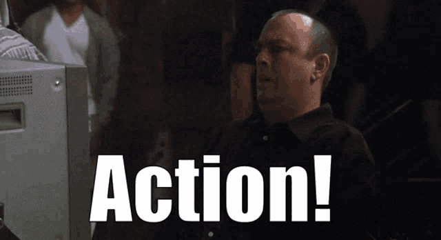 a man sitting in front of a tv with the word action written on the screen