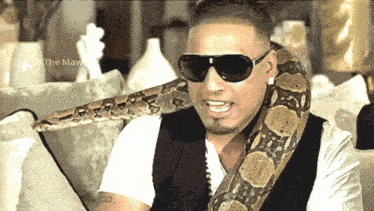 a man with a snake around his neck is wearing sunglasses and a white shirt