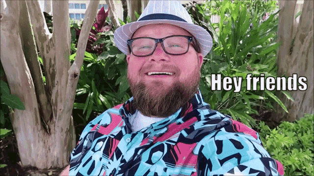a man with a beard wearing a hat and glasses says hey friends