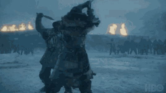 a group of soldiers are standing in the snow in front of a wall .
