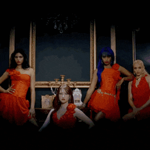 four women in red dresses are posing in front of a picture frame