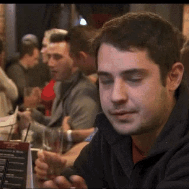 a man is sitting at a table with a menu on it