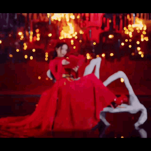 a woman in a red dress is reading a book while sitting on a swan .