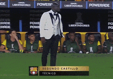 a man in a tuxedo stands in front of a sign that says " segundo castillo "
