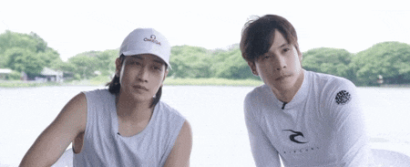 a man wearing an omega hat stands next to another man